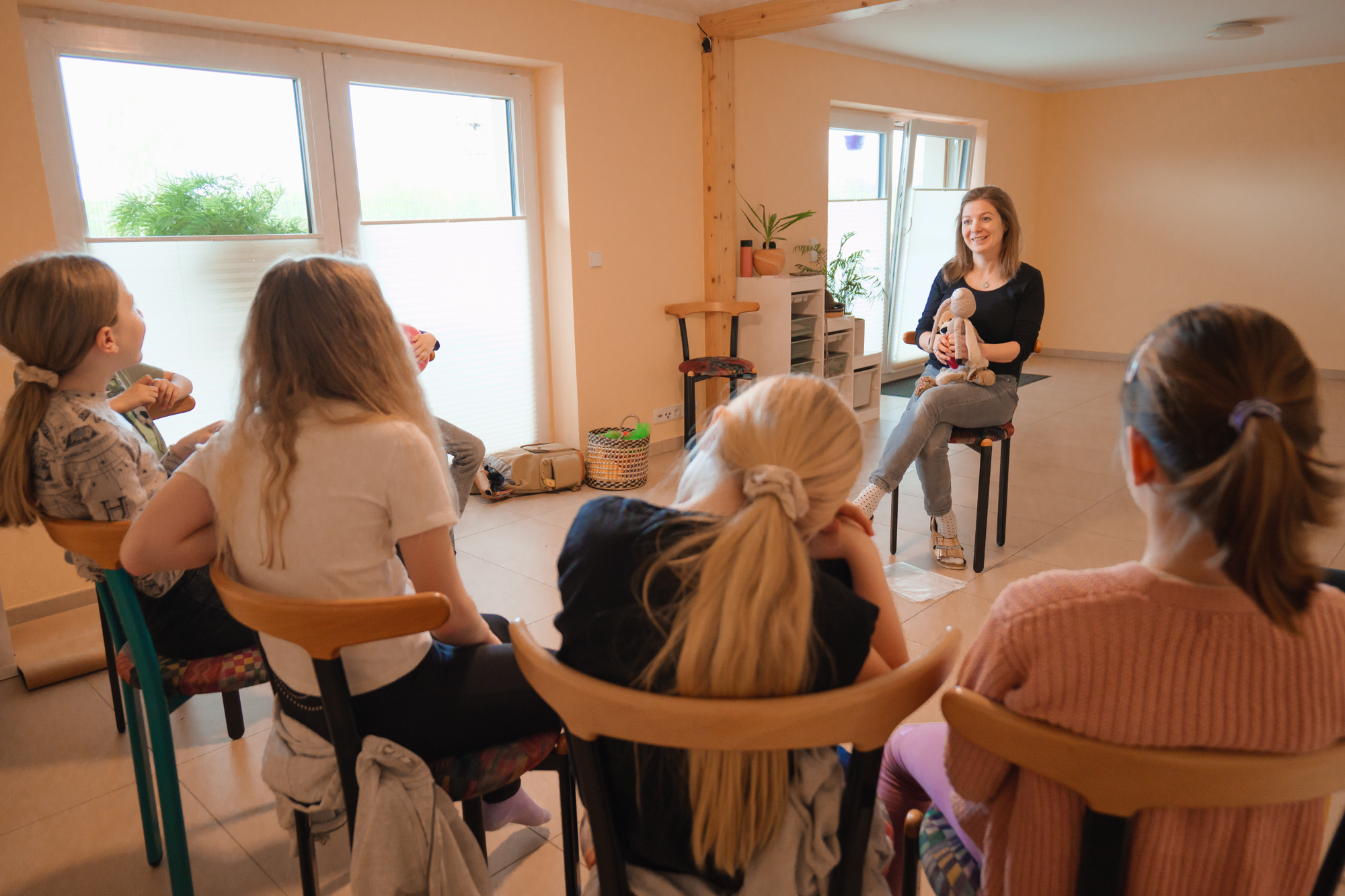 Sarah Veyel sitzt mit einer Gruppe Kinder im Stuhlkreis bei einem Trompetenpower-Training